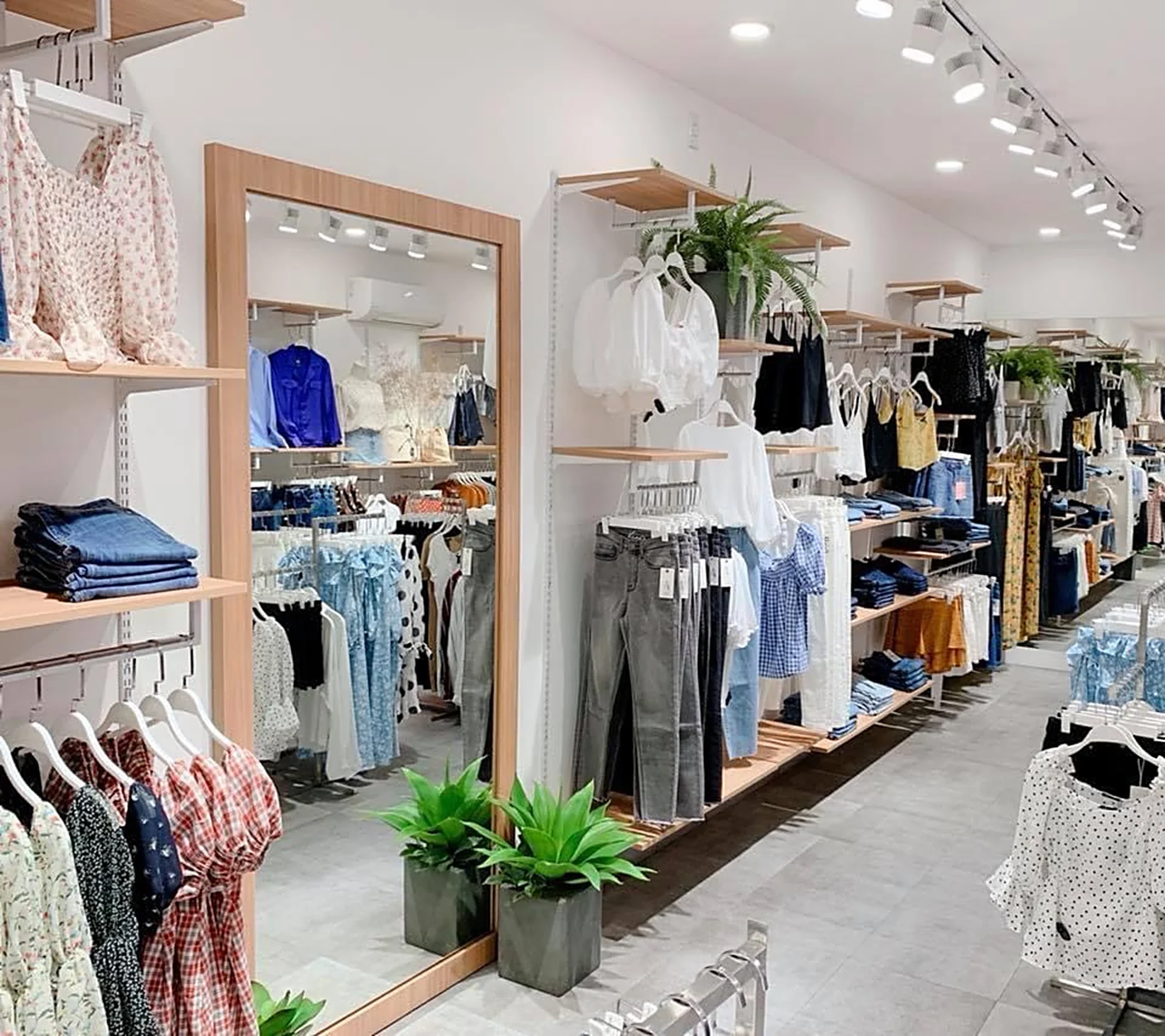 Cửa hàng thời trang sáng sủa với các giá treo quần áo